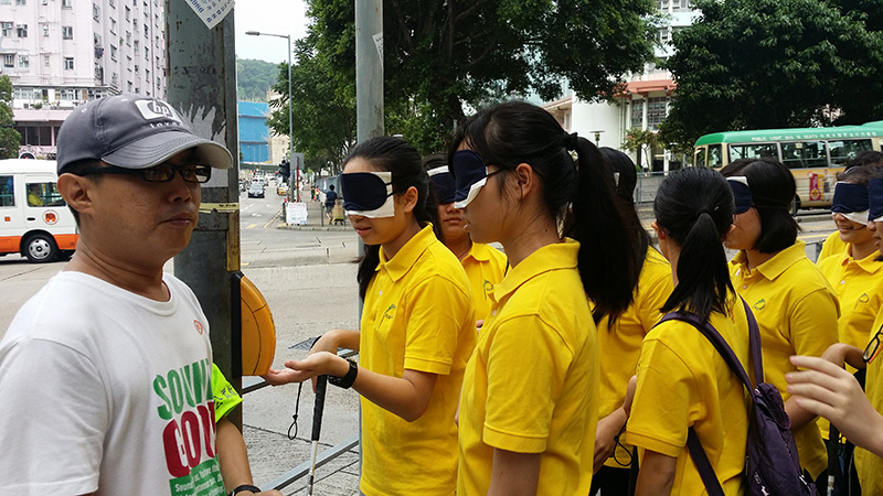 公眾教育大使帶領蒙眼的參加者在街上進行體驗